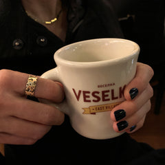 Flat band with organic holes and edges; shown in high polish; 7 mm width, 14k polished version shown on hand holding coffee mug