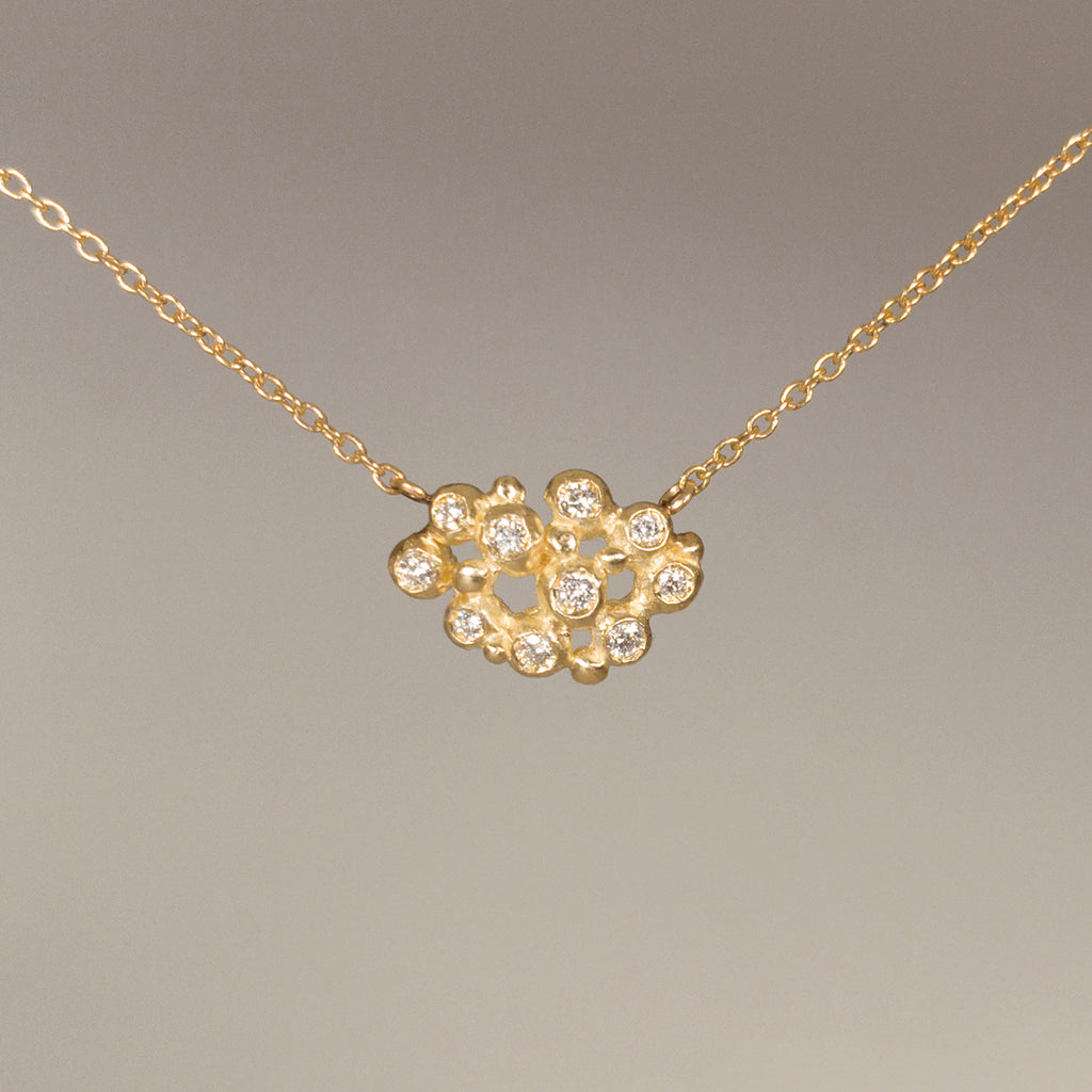 Necklace is cluster of 10 tiny diamond "buds"; shown in yellow gold with a satin finish